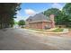Exterior backyard view of brick home with driveway, patio and mature landscaping at 84 Nw Gloster Nw Rd, Lawrenceville, GA 30044