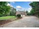 Traditional brick home featuring a three-car garage, lush green lawn, and well-manicured landscaping at 84 Nw Gloster Nw Rd, Lawrenceville, GA 30044