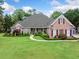 Beautiful brick home featuring manicured lawn, lush landscaping, and red shutters at 84 Nw Gloster Nw Rd, Lawrenceville, GA 30044
