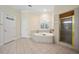 Spa-like main bathroom featuring a corner tub, glass shower, and neutral tile at 84 Nw Gloster Nw Rd, Lawrenceville, GA 30044