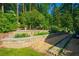 Landscaped backyard features a stone retaining wall, lush greenery, and a charming stone pathway at 1382 Varner Rd, Marietta, GA 30062