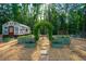 Backyard featuring a glass greenhouse, raised garden beds, and ample space for outdoor enjoyment at 1382 Varner Rd, Marietta, GA 30062