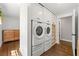 A functional laundry area with modern washer and dryer units, built-in storage and wood floor at 1382 Varner Rd, Marietta, GA 30062