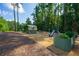 Wooded backyard features a playground with raised garden beds, swing set, and a slide at 1382 Varner Rd, Marietta, GA 30062