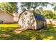 Charming backyard barn with gray wood and white trim with doors and a ramp at 184 Wildflower Dr, Social Circle, GA 30025