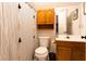 Bathroom with a tiled shower with striped curtain and wooden cabinets at 184 Wildflower Dr, Social Circle, GA 30025