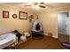 Well-lit bedroom featuring a ceiling fan, wall decorations, and comfortable carpet flooring at 184 Wildflower Dr, Social Circle, GA 30025