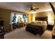Comfortable primary bedroom with a ceiling fan, large bed, and a vanity near the window at 184 Wildflower Dr, Social Circle, GA 30025