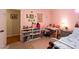 Bright pink bedroom featuring a bed, bookshelf, desk, and cozy decor at 184 Wildflower Dr, Social Circle, GA 30025