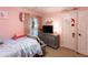 Inviting pink bedroom featuring bed, dresser, and window with natural light at 184 Wildflower Dr, Social Circle, GA 30025