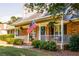 Close up of the charming brick house and its inviting front porch with an American flag at 184 Wildflower Dr, Social Circle, GA 30025