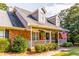 Close up of the charming brick house and its inviting front porch with an American flag at 184 Wildflower Dr, Social Circle, GA 30025