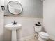 Chic powder room with a pedestal sink, decorative mirror, and patterned wallpaper at 76 Mayson Avenue Northeast Ne, Atlanta, GA 30307