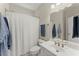 Bright bathroom features a large mirror, white sink, and shower with a patterned curtain at 956 Kinghorn Nw Dr, Kennesaw, GA 30152