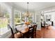 Sunlit dining room with a wooden table, chandelier, and views of the backyard at 956 Kinghorn Nw Dr, Kennesaw, GA 30152
