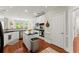 Bright kitchen boasts stainless appliances, white cabinetry, dark countertops, and wood flooring at 956 Kinghorn Nw Dr, Kennesaw, GA 30152