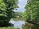 Scenic view of the community lake surrounded by lush green trees and foliage at 956 Kinghorn Nw Dr, Kennesaw, GA 30152