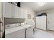 Functional laundry room with white cabinets and modern washer and dryer units at 956 Kinghorn Nw Dr, Kennesaw, GA 30152