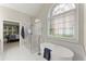 Luxurious bathroom with a soaking tub, glass shower, and an arched window at 956 Kinghorn Nw Dr, Kennesaw, GA 30152