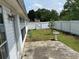 Backyard with concrete patio, green grass, white fence, and a view of the home's exterior at 2256 Hansford Pass, Buford, GA 30519