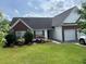 Charming single-story home featuring a well-manicured lawn, brick accents, and a two-car garage at 2256 Hansford Pass, Buford, GA 30519