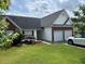 Well-kept home showcasing a green lawn, brick accents, and a driveway leading to a two-car garage at 2256 Hansford Pass, Buford, GA 30519