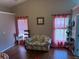 Bright living room featuring hardwood floors, natural light, and cozy floral sofa at 2256 Hansford Pass, Buford, GA 30519