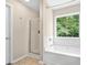 Bright bathroom features a garden tub with a window and glass enclosed shower at 3065 Moser Way, Marietta, GA 30060