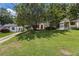Home exterior with a well-manicured lawn, framed by mature trees on a sunny day at 1932 Neely Ave, Atlanta, GA 30344