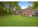 Spacious backyard featuring a well-maintained lawn and the brick facade of the house at 59 Oakmont Nw Dr, Marietta, GA 30064