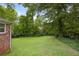 Large backyard, featuring mature trees and lush green lawn, with a portion of the home visible to the left at 59 Oakmont Nw Dr, Marietta, GA 30064