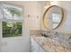Bright bathroom with granite countertops, decorative mirror, and garden window at 59 Oakmont Nw Dr, Marietta, GA 30064