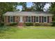 Charming brick home with manicured lawn, black shutters, and brick steps to the front door at 59 Oakmont Nw Dr, Marietta, GA 30064