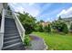 Scenic backyard view with lush greenery, a stone pathway, and stairs leading to upper-level deck at 8 Southview Dr, Cartersville, GA 30121