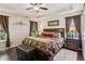 Primary bedroom with tray ceilings, dark wood floors and windows to let the light in at 1714 Indian Way, Cumming, GA 30040