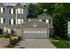 Attractive townhome featuring a two-car garage, classic siding, and landscaped front yard at twilight at 1714 Indian Way, Cumming, GA 30040