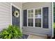 Welcoming front entrance with a wreath, green ferns, a sidelight window, and black shutters at 1714 Indian Way, Cumming, GA 30040
