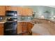Galley-style kitchen with wood cabinets, black appliances, and speckled countertops at 1714 Indian Way, Cumming, GA 30040