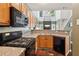 Open kitchen with stainless sink and black appliances overlooks the living room and fireplace at 1714 Indian Way, Cumming, GA 30040