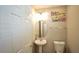 Half bathroom with modern lighting, white vanity, round mirror and contemporary artwork at 400 Silver Spring St, Dallas, GA 30157