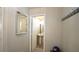 Powder room with pedestal sink, round mirror, adjacent to hallway with coat hooks at 400 Silver Spring St, Dallas, GA 30157