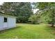 Lush green back yard with mature trees and a privacy fence at 4523 Doc Sams Rd, Cumming, GA 30028
