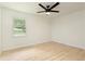 Bedroom featuring a modern ceiling fan, large window overlooking the backyard and light colored flooring at 4523 Doc Sams Rd, Cumming, GA 30028
