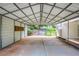 Covered carport with concrete floor, gated driveway and house on right at 4523 Doc Sams Rd, Cumming, GA 30028