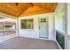 Inviting front porch featuring a wood ceiling, brick accents, and black railings at 4523 Doc Sams Rd, Cumming, GA 30028