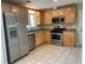 Kitchen boasts stainless steel appliances, stone countertops and tile flooring at 1150 Terramont Dr, Roswell, GA 30076