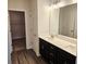 Bathroom featuring a double vanity, modern fixtures, and a view into the walk-in closet at 145 Scarlett Place Dr, Bowdon, GA 30108