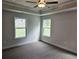 Inviting bedroom with neutral walls, plush carpeting, a tray ceiling, and natural lighting at 145 Scarlett Place Dr, Bowdon, GA 30108