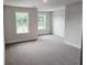 Spacious bedroom featuring two windows, neutral carpet, and crisp white trim at 145 Scarlett Place Dr, Bowdon, GA 30108