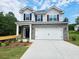 Charming two-story home featuring brick accents, a two-car garage, and a welcoming covered porch at 145 Scarlett Place Dr, Bowdon, GA 30108